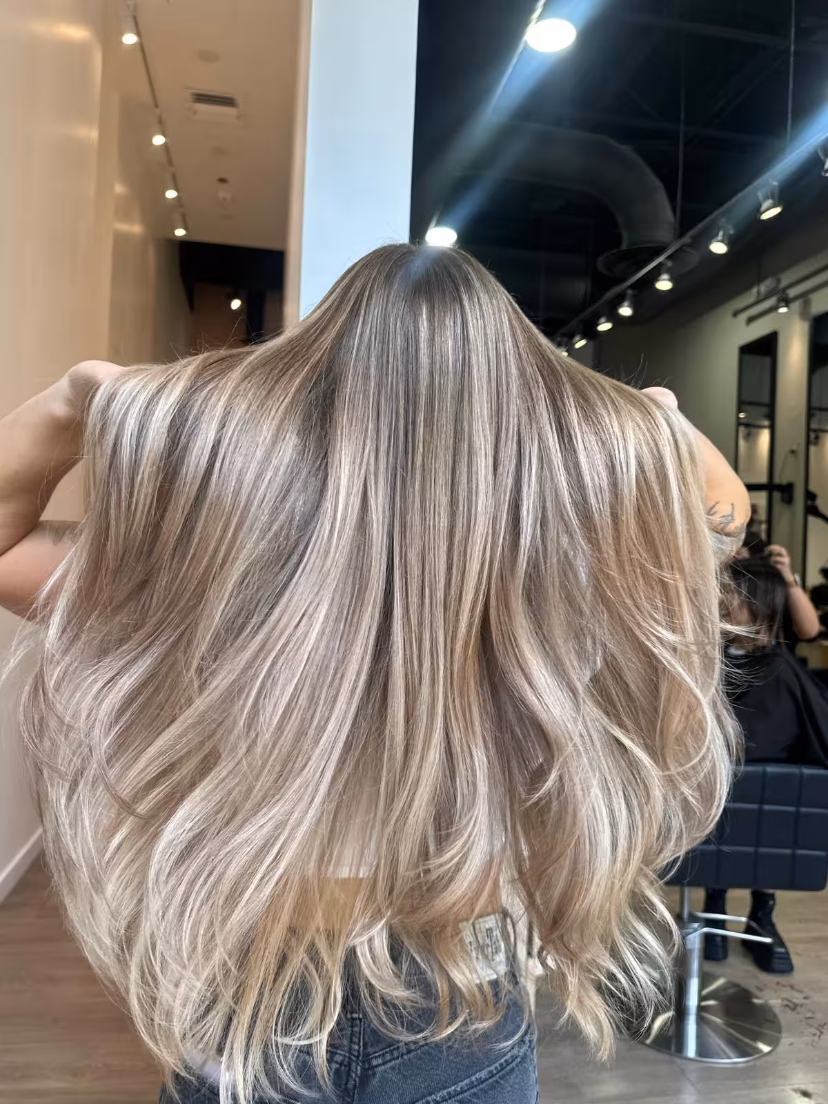 Long ash-blonde balayage with dimensional lowlights and volume, back view - highlights Honolulu